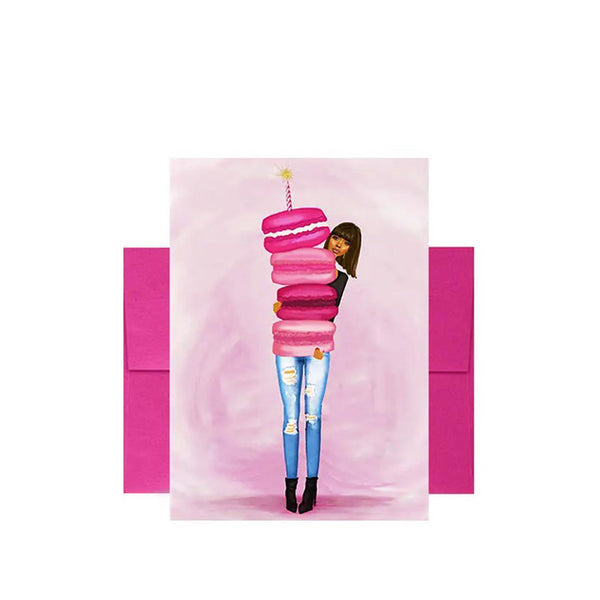 Birthday greeting card featuring lady with oversized macarons with a birthday candle in front of envelope